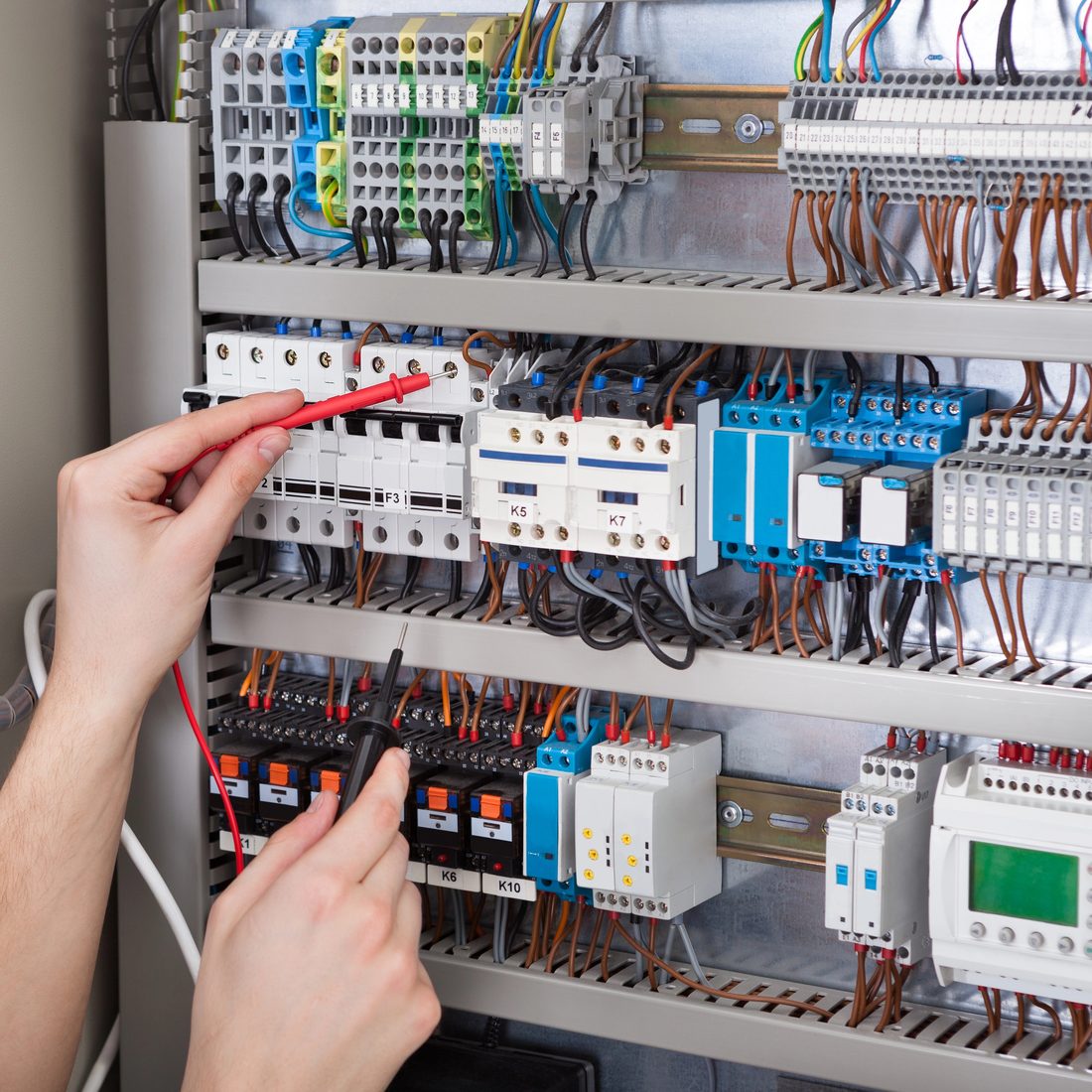 AAT technician wiring the Taktos Edge gateway into a control panel — installed and commissioned on the line, not a license you wire up alone.
